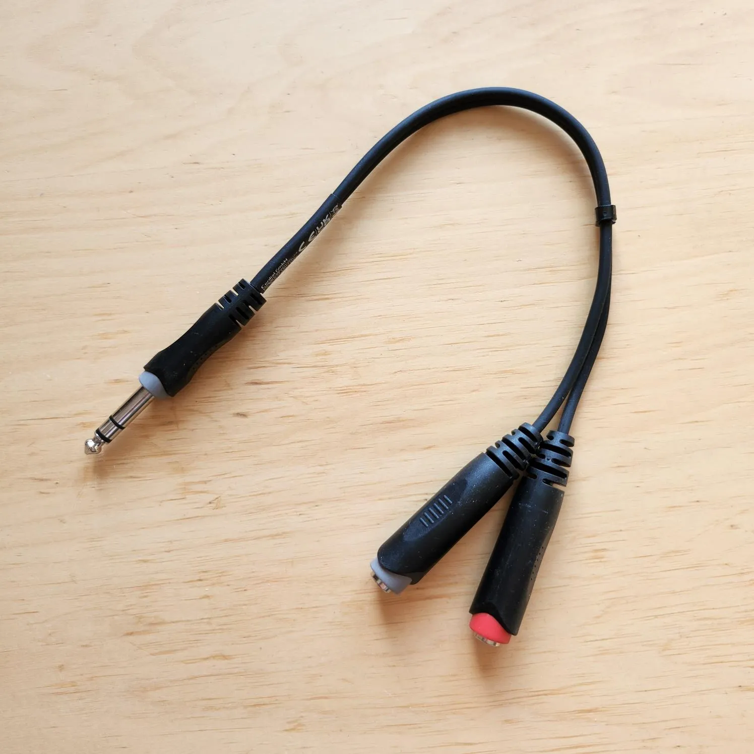 Photo of a Y splitter, showing its TRS plug and two jacks, one red, one white