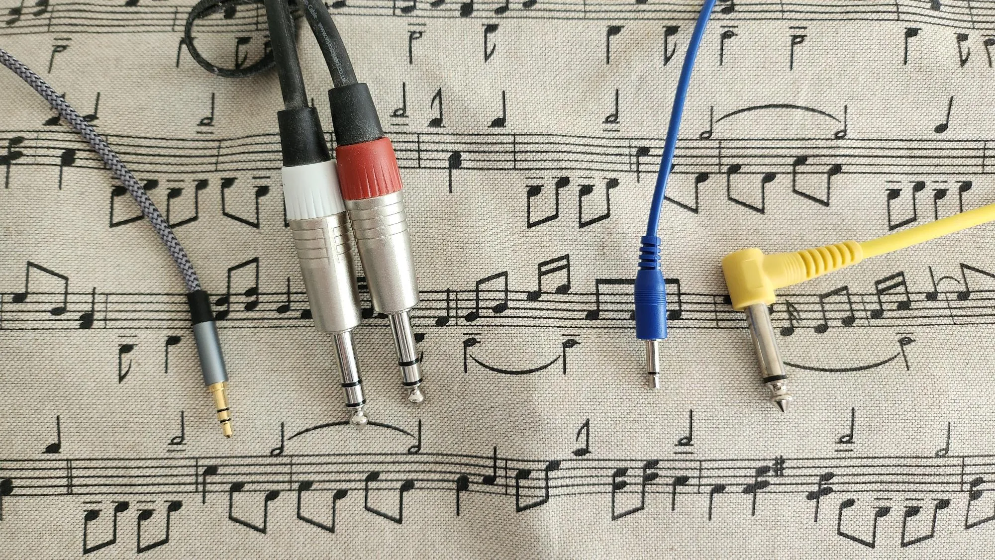 Four examples of audio cables, covering all combinations of quarter and eighth inch and TS and TRS